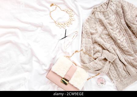 Frauen Kleidung und Accessoires auf weißem Hintergrund gesetzt. Damen warmer Pullover, Tasche, Brille. Einkaufskonzept. Flach liegend, Draufsicht. Stockfoto
