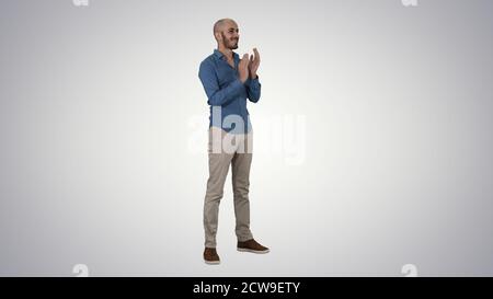 Handsom arab klatschte in die Hände und applaudierende auf Gradienten-Backgroun Stockfoto