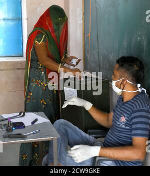 Beawar, Indien. September 2020. Rajasthani verschleierte Frau warf ihre Stimme in einem Wahllokal während Panchayati Raj Wahlen, inmitten der laufenden Coronavirus-Pandemie, in Jhala KI Chauki Dorf in der Nähe von Beawar. Über 83.50 Prozent der 31.95-lakh Wähler ihre Stimmen in der ersten Phase der 947 Gramm Panchayat (Dorfrat) Wahlen in 25 Bezirken im ganzen Staat. Die Richtlinien im Zusammenhang mit COVID-19 wurden bei der Wahl nicht befolgt. Die Wähler tragen Gesichtsmasken, haben aber keine soziale Distanzierung beibehalten. (Foto von Sumit Saraswat/Pacific Press) Quelle: Pacific Press Media Production Corp./Alamy Live News Stockfoto