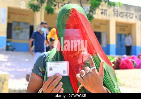 Rajasthani verschleierte Frau zeigt ihre eingekränkten Finger und ID nach Besetzung Abstimmung während Panchayati Raj Wahlen, inmitten der laufenden Coronavirus-Pandemie, in Jhala KI Chauki Dorf in der Nähe von Beawar. Über 83.50 Prozent der 31.95-lakh Wähler ihre Stimmen in der ersten Phase der 947 Gramm Panchayat (Dorfrat) Wahlen in 25 Bezirken im ganzen Staat. Die Richtlinien im Zusammenhang mit COVID-19 wurden bei der Wahl nicht befolgt. Die Wähler tragen Gesichtsmasken, haben aber keine soziale Distanzierung beibehalten. (Foto von Sumit Saraswat/Pacific Press) Stockfoto