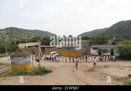 Sheoganj, Indien. September 2020. Die Menschen warten in einer Warteschlange, um ihre Stimmen außerhalb eines Wahlzentrums während der ersten Phase der gram panchayat (Dorfrat) Wahlen in einem Dorf Sirohi Bezirk im westlichen indischen Bundesstaat Rajasthan zu werfen. Kredit: SOPA Images Limited/Alamy Live Nachrichten Stockfoto