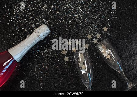Zwei Sektgläser mit Konfetti auf schwarzem Hintergrund. Stockfoto