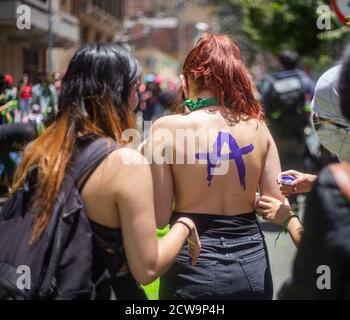 Bogota, Kolumbien. September 2020. Eine Frau malt den Rücken einer anderen Frau. An der Spitze des Obersten Gerichtshofs von Kolumbien, trafen sie sich, um für die Legalisierung von Abtreibungen im Land zu demonstrieren, war ein Teil des Protests mit grüner Farbe ein früheres Graffiti von nicht-Abtreibungsbefürwortern gemacht zu bedecken. Quelle: Daniel Garzon Herazo/ZUMA Wire/Alamy Live News Stockfoto