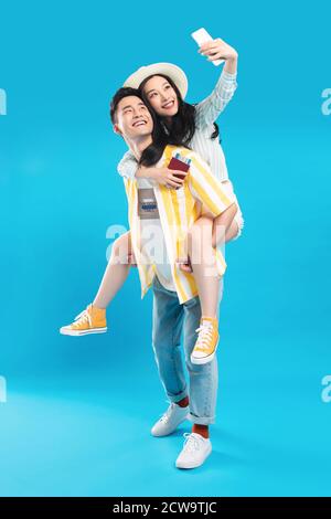 Junger Mann, der eine Freundin mit einem Mobiltelefon trägt Stockfoto