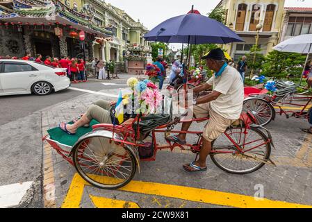 George Town, Penang, Malaysia - 1. Dezember 2019: Straßenleben von Trishaw Fahrer oder Rikschas in George Town, Penang, Malaysia bei bewölktem Wetter. Das ist es Stockfoto