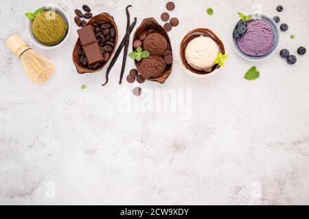 Verschiedene Eis-Aromen in Schale Heidelbeere, grüner Tee, Kokosnuss und Schokolade Setup auf weißem Stein Hintergrund. Stockfoto