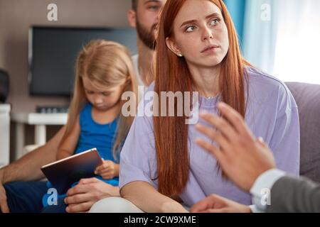 Junge kaukasische Familie expain Situation, Probleme der Familie Psychologe. Professionelle Therapeut aufmerksam auf sie hören, versuchen zu helfen, geben Ratschläge. Letzte Chance, die Familie zu retten Stockfoto