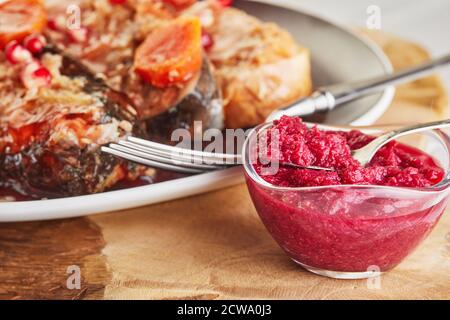 Meerrettich für Gefiltenfische mit Karotten und Granatäpfeln, authentisches jüdisches Gericht. Stockfoto