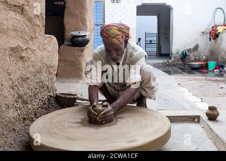 Indian Mann Formen Ton mit einem Töpfer Rad in ländlichen Rajasthan, Indien Stockfoto