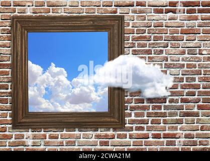 Denken Sie über den Tellerrand hinaus. Hölzerner Bilderrahmen mit Foto des blauen Himmels mit Wolken auf Backstein Wand Hintergrund. Eine Wolke schwebt aus einem Bilderhang Stockfoto
