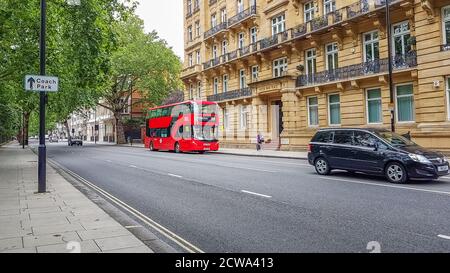 London, Großbritannien - 8. Juli 2020: Moderner roter Doppeldeckerbus, der am Hyde Park Place Gebäude im Zentrum Londons vorbeifährt. Es steht darauf - Piccadilly Circus 94. Stockfoto