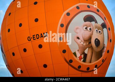 Die neue Registrierung 'G-EDAM', um die Käseverbindung in den Wallace & Gromit Animationen hervorzuheben, gedruckt auf der Seite des Heißluftballons während seines Jungfernflugs in Form von Wallace und Gromit's Moon Rocket nach dem Start vom Lloyds Amphitheatre in Bristol. Stockfoto