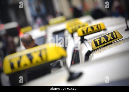 Thementaxis mit Bildern. Taxi, Taxiunternehmen, Schilder auf den Dächern der Taxis im Münchner Tal am 28. September 2020. Reflexion. Weltweite Nutzung Stockfoto