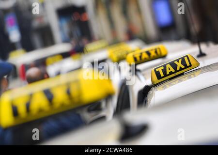 Thementaxis mit Bildern. Taxi, Taxiunternehmen, Schilder auf den Dächern der Taxis im Münchner Tal am 28. September 2020. Reflexion. Weltweite Nutzung Stockfoto