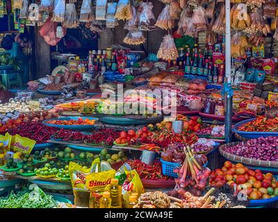 Riesige Orangenbananen hängen an einem Marktstand in einer kleinen Stadt auf der Insel Ambon, Maluku, Indonesien. Asien Stockfoto