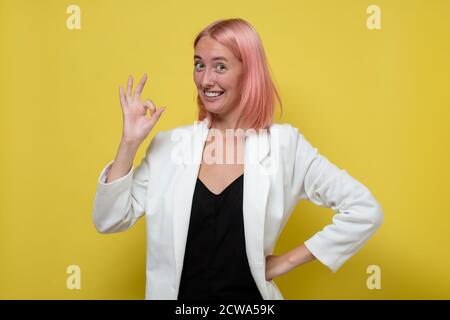 Fröhliche junge kaukasische Frau zeigt Geste ok geben einen Rat. Stockfoto