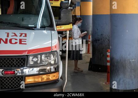 Jerusalem, Israel. September 2020. Eine junge Jüdin betet auf dem Parkplatz des Shaare Zedek Medical Center, während Krankenhäuser im ganzen Land sich der Kapazitätsgrenze nähern. Israel hat bis heute sogar die USA in Coronavirus-Todesfällen pro Kopf übertroffen. Kredit: Nir Alon/Alamy Live Nachrichten Stockfoto