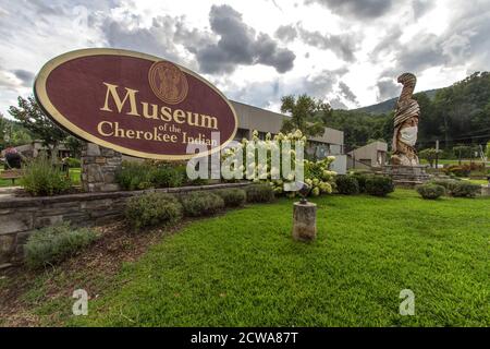 Cherokee, North Carolina, USA - 12. August 2020: Großer Totem Pole im Museum des Cherokee Indianers mit Gesichtsmaske zur Prävention von COVID 19. Stockfoto