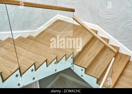 Holztreppe mit Glasgeländer und Holzgeländer. Blick von oben Stockfoto