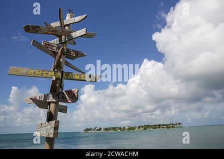 Beliebte Richtungen und Entfernungen [in Meilen] Schilder an der ebenso beliebten Sunset Pier Bar auf Key West, Florida, USA. Stockfoto