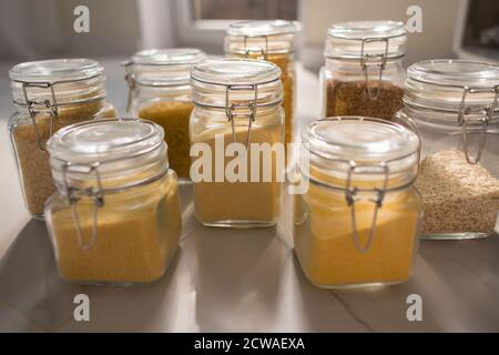 Sammlung von Getreideprodukten in Vorratsgefäßen über in der Küche. Krug mit Cerealien im Küchenschrank Stockfoto
