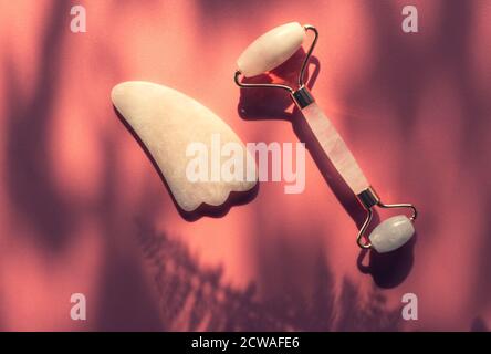 Gesichts Jade Massage Derma Roller oder Gua Sha mit trendigen Schatten, Schönheit Anti-Aging-Tools. Stockfoto