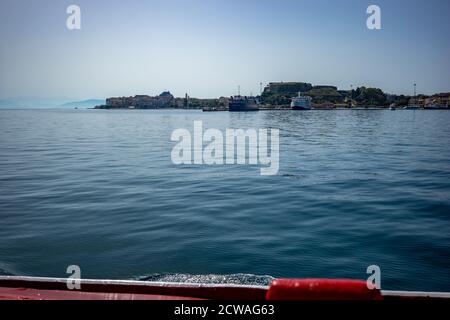 In den Hafen von Kerkira. Korfu Insel, Griechenland. Klassische blaue Farbe, Berge und Himmel im Hintergrund. Atemberaubende Meereslandschaft. Schöne Aussicht von der Fähre aus Saranda, Albanien Stockfoto
