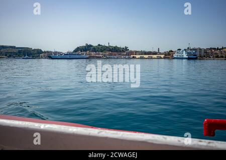 In den Hafen von Kerkira. Korfu Insel, Griechenland. Klassische blaue Farbe, Berge und Himmel im Hintergrund. Atemberaubende Meereslandschaft. Schöne Aussicht von der Fähre aus Saranda, Albanien Stockfoto