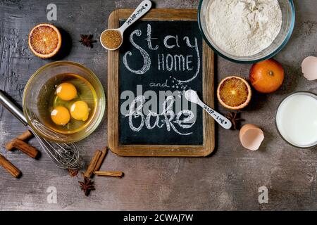 Zutaten zum Backen. Bleib zu Hause Quarantäne Isolation Zeitraum Konzept. Vintage Kreidetafel mit handgeschriebener Kreideschrift bleiben zu Hause und backen. Grau t Stockfoto