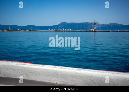 In den Hafen von Kerkira. Korfu Insel, Griechenland. Klassische blaue Farbe, Berge und Himmel im Hintergrund. Atemberaubende Meereslandschaft. Schöne Aussicht von der Fähre aus Saranda, Albanien Stockfoto