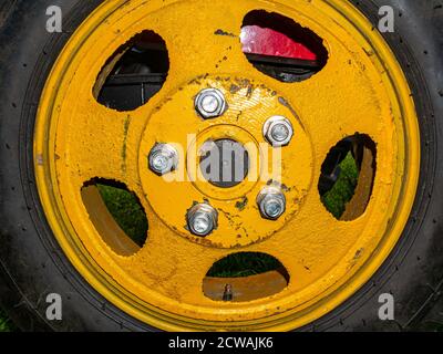 Landwirtschaftliche Traktorrad mit gelber Scheibe auf Muttern. Stockfoto
