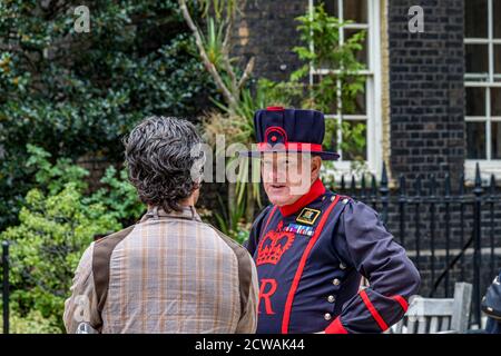 Ein Yeoman Warder am Tower of London spricht mit einem Besucher, Tower of London, London EC3 Stockfoto