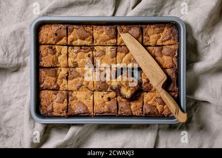 Trend Backen Brookies Schokolade Brownies und Cookies hausgemachte Kuchen durch Quadrate in Backblech auf grauem Leinentuch Hintergrund geschnitten. Flach, Platz Stockfoto