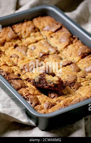Trend Backen Brookies Schokolade Brownies und Cookies hausgemachten Kuchen von Quadraten in Backblech auf grauem Leinenstoff Hintergrund geschnitten. Stockfoto