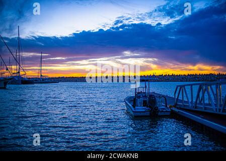 Die Masten der Yacht werden von einem wunderschönen Sonnenuntergang am Mittelmeer umrahmt. Fotografiert in Israel Stockfoto