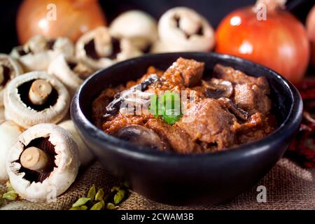 Walisisches Rindfleisch Curry in einer rustikalen Schüssel mit Zutaten in Der Hintergrund Stockfoto