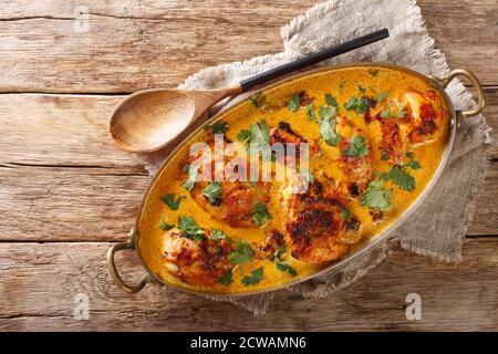 Kuku Paka ist ein gewürztes Huhn und Kokosnuss-Curry-Gericht, das voller exotischer Aromen in der Pfanne auf dem Tisch ist. Horizontale Draufsicht von oben Stockfoto