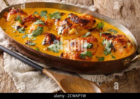 Kenyan Kuku Paka ist ein Huhn über Holzkohle gebraten und dann in einem Kokosnuss-Curry in der Pfanne auf dem Tisch gekocht. Horizontal Stockfoto