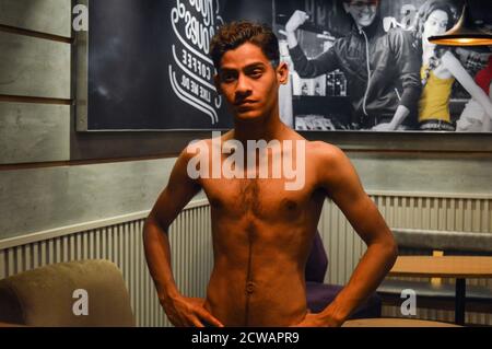 Indische Jungen geben Posen für Mode-Foto-Shooting im Studio mit Specs, Kopfhörer, Glühbirne Requisiten. Stockfoto