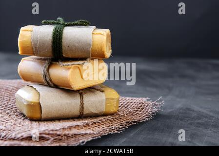 Stücke von Haushaltsseife mit Jute Seil gebunden, antiken Holzhintergrund. Umweltfreundliches Produkt - das Konzept der Sauberkeit und Gesundheit. Stockfoto