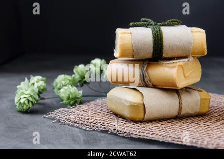 Stücke von Haushaltsseife mit Jute Seil gebunden, antiken Holzhintergrund. Schönes ökologisches Stillleben zum Thema Sauberkeit Stockfoto