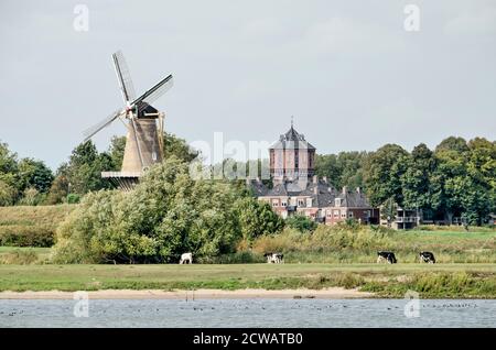 Gorinchem, Niederlande, 23. September 2020: Blick in die Auen mit weidenden Kühen, einer Windmühle und einem Wasserturm Stockfoto