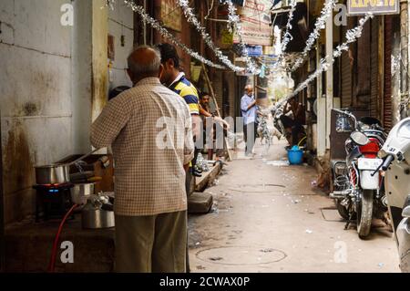 Ein Mann macht seine Arbeit auf verkehrsreichen Straßen in chandani chowk, Alt-delhi, indien. Stockfoto