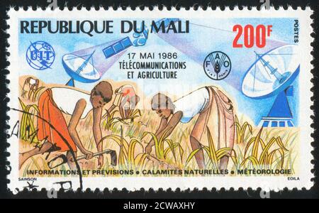 MALI - UM 1986: Briefmarke gedruckt von Mali, zeigt Telekommunikation und Landwirtschaft, um 1986 Stockfoto