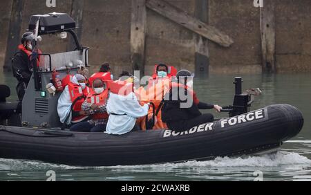 Eine Gruppe von Menschen, die als Migranten gelten, werden von der Border Force nach einem kleinen Bootsunfall im Kanal nach Dover, Kent, gebracht. Stockfoto