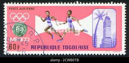 TOGO - UM 1967: Briefmarke gedruckt von Togo, zeigt Mexiko, olympisches Emblem, Läufer, um 1967 Stockfoto