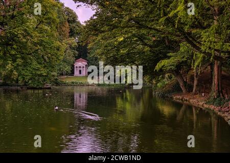 Bäume und ein kleiner neoklassizistischer kleiner Tempel spiegeln sich in einem Waldteich im Park von Monza, Lombardei, Italien Stockfoto