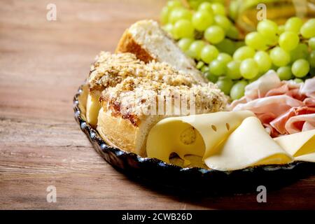 Vorspeisen Antipasti mit weißen sizilianischen Focaccia. Traditionelle Brotscheibe mit Zwiebel serviert mit Schinken, Käse, Trauben über Holzbac Stockfoto