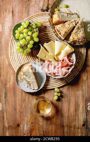 Vorspeisen Antipasti mit weißen sizilianischen Focaccia. Traditionelle Brotscheiben Kuchen mit Zwiebeln serviert mit Schinken, Käse, Trauben und Glas WH Stockfoto