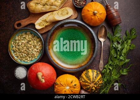 Leere Keramikschüssel und Zutaten bereit für Kürbissuppe. Mit verschiedenen Arten von kleinen Kürbissen Stockfoto